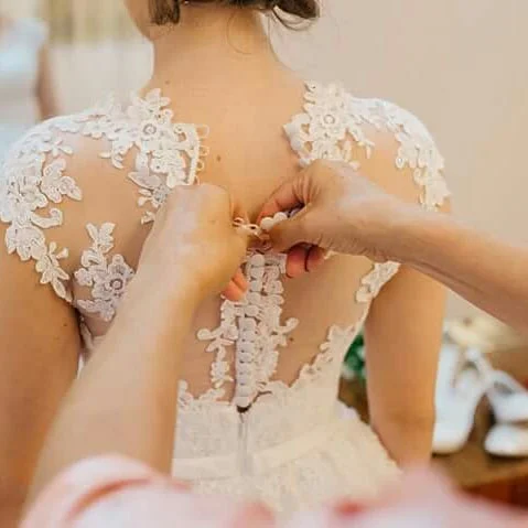 foto colocando o vestido de noiva
